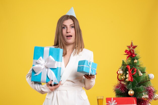 Vue de face femme médecin tenant des cadeaux de Noël