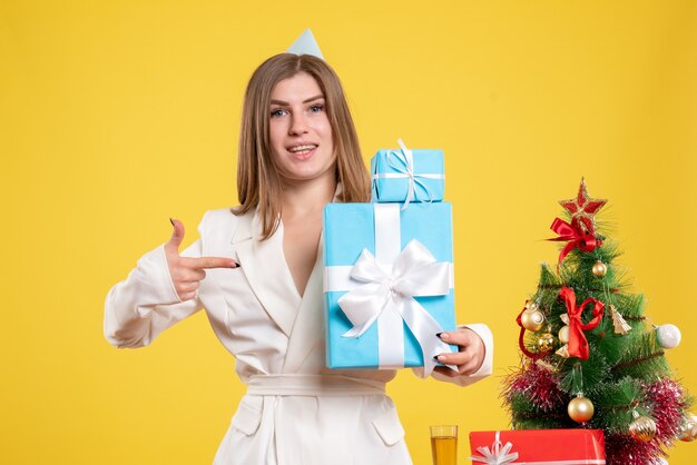 Vue de face femme médecin tenant des cadeaux de Noël