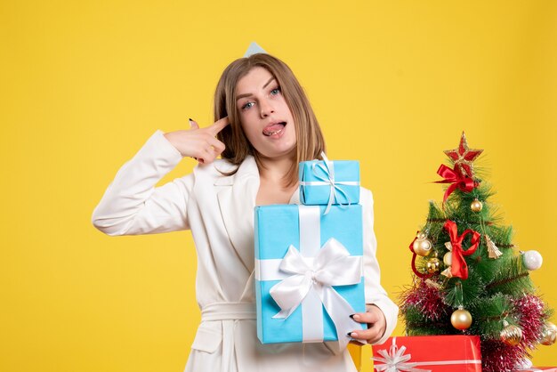 Vue de face femme médecin tenant des cadeaux de Noël