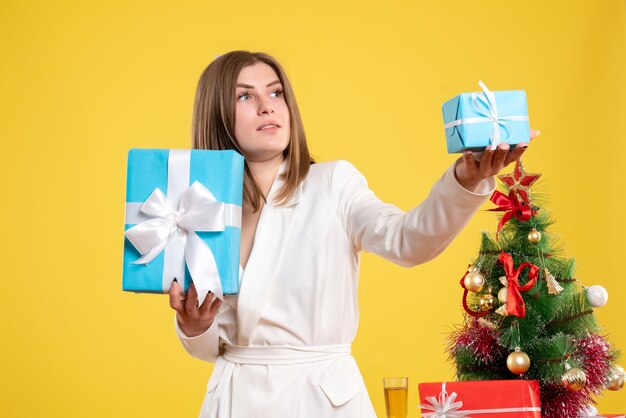 Vue de face femme médecin tenant des cadeaux de Noël