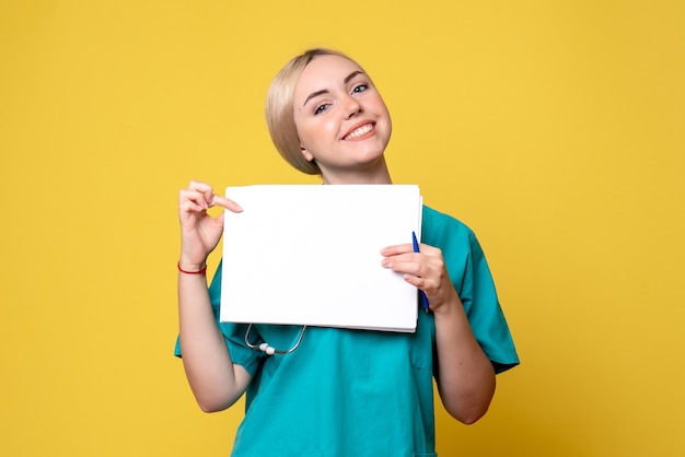 Vue de face femme médecin tenant différents papiers, virus de la santé pandémique infirmière infirmière de l'hôpital Covid-19