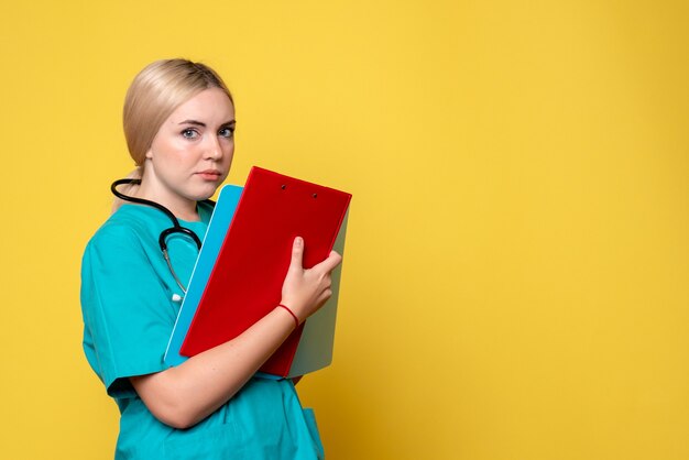 Vue de face femme médecin tenant des notes et des papiers, ambulance covid-19 infirmière hôpital médical