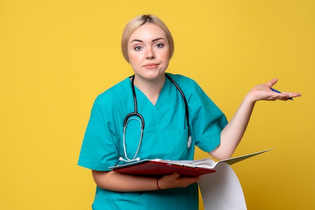 Vue de face femme médecin tenant des notes et des papiers, infirmière de la santé de l'hôpital médical du virus covid-19