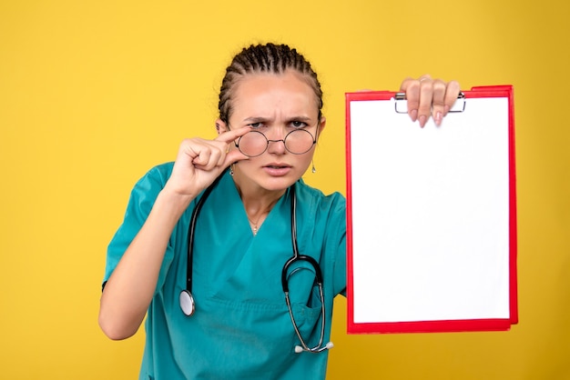Vue de face femme médecin tenant le presse-papiers médical vide, couleur hôpital émotion covid-19 medic health