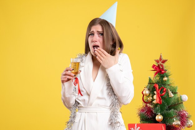 Vue de face femme médecin tenant un verre de champagne et célébrant