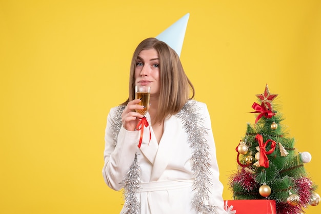 Vue de face femme médecin tenant un verre de champagne et célébrant