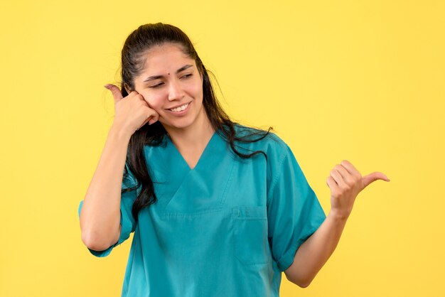 Vue de face femme médecin en uniforme mettant la main