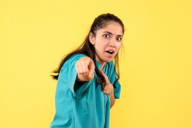 Vue de face femme médecin en uniforme pointant vers l'avant