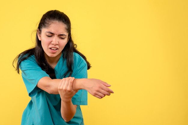 Vue de face femme médecin en uniforme tenant son bras blessé debout