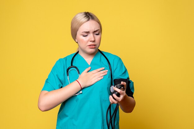 Vue de face femme médecin vérifiant sa pression, infirmière santé medic Covid-19 hôpital virus ambulance