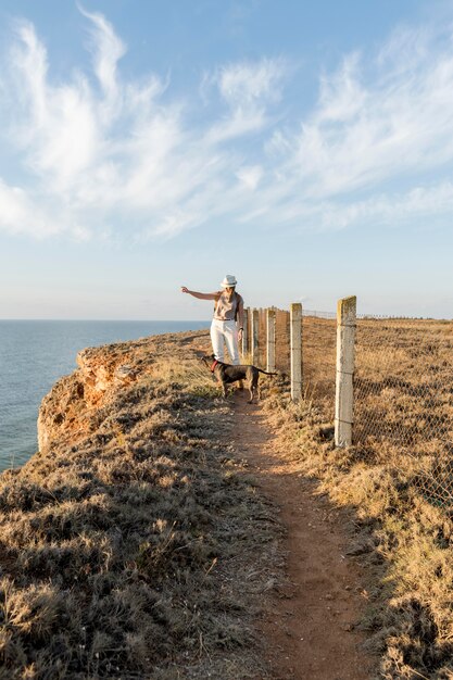 Vue de face femme montrant une direction à son chien