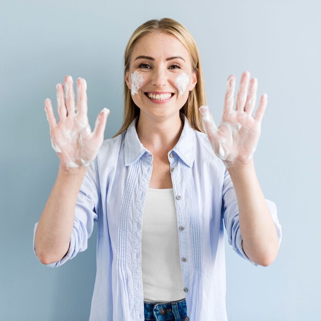 Vue de face de femme montrant ses mains savonneuses