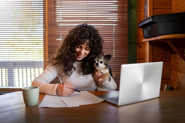 Vue de face femme avec ordinateur portable à la maison