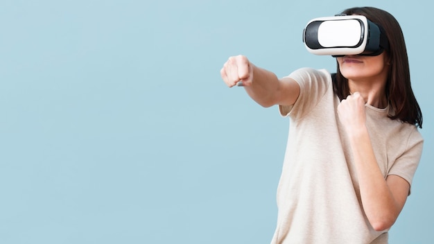 Vue de face de femme portant un casque de réalité virtuelle avec espace copie