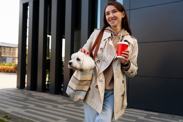 Vue de face femme portant un chiot dans un sac