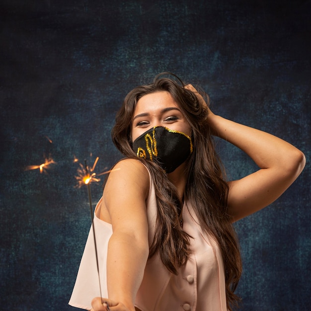 Vue de face d'une femme portant un masque avec un feu d'artifice