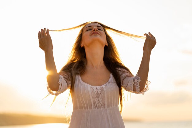 Vue de face de la femme posant au coucher du soleil