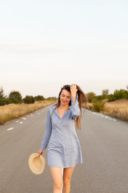 Vue de face de la femme posant au milieu de la route avec espace copie