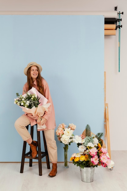 Vue de face de la femme posant avec bouquet de fleurs de printemps