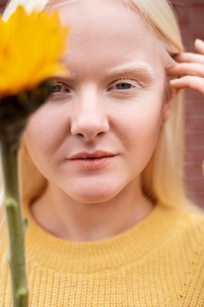 Vue de face femme posant avec fleur