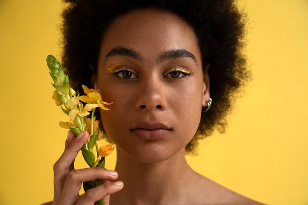 Vue de face femme posant avec fleur