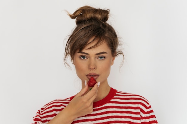 Vue de face femme posant avec fraise