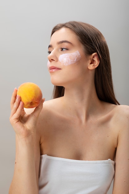 Vue de face femme posant avec des fruits