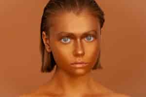 Photo gratuite vue de face femme posant avec de la peinture corporelle dorée