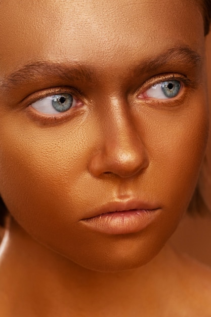 Photo gratuite vue de face femme posant avec de la peinture corporelle dorée