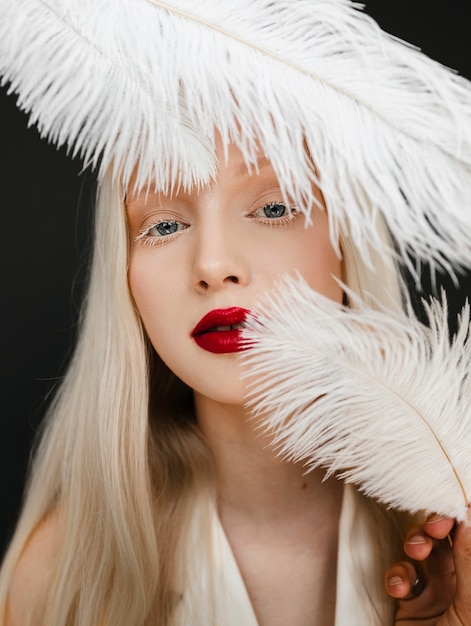 Vue de face femme posant avec des plumes