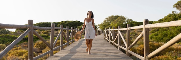 Vue de face de la femme posant sur le pont dans la nature