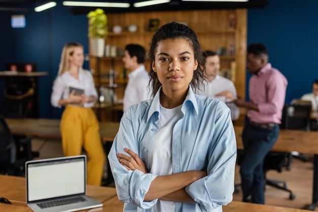 Photo gratuite vue de face de la femme posant à son bureau à côté de l'ordinateur portable