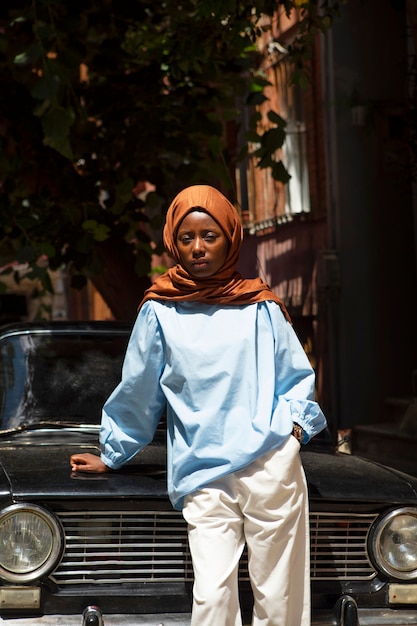 Vue de face femme posant avec voiture