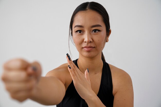 Vue de face femme pratiquant le tai chi à l'intérieur