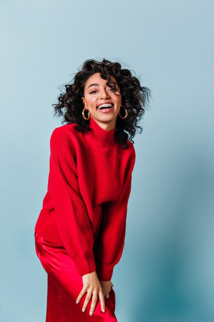 Vue de face de la femme qui rit en pull rouge