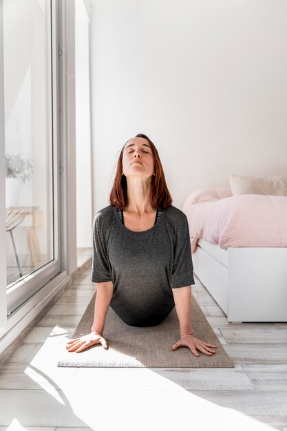 Vue de face femme qui s'étend sur tapis