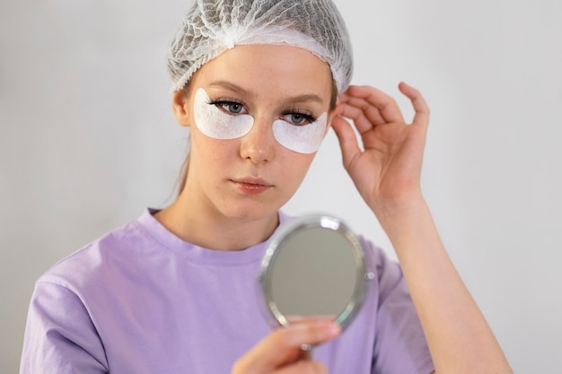 Photo gratuite vue de face femme regardant dans le miroir