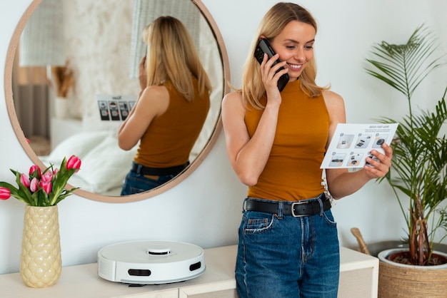 Photo gratuite vue de face femme avec robot aspirateur à la maison