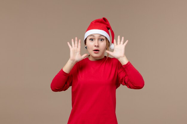 Vue de face de femme en rouge avec un visage surpris sur marron