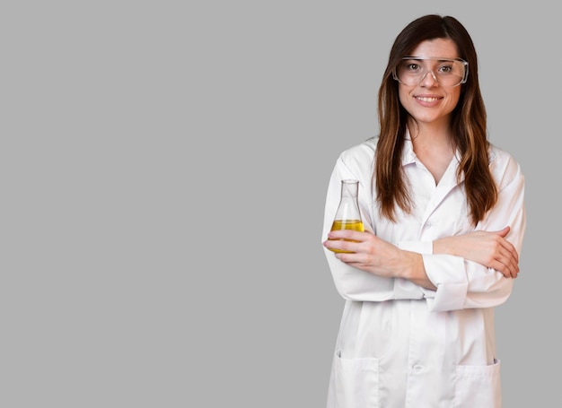 Vue de face de la femme scientifique avec des lunettes de sécurité tenant le tube à essai avec copie espace