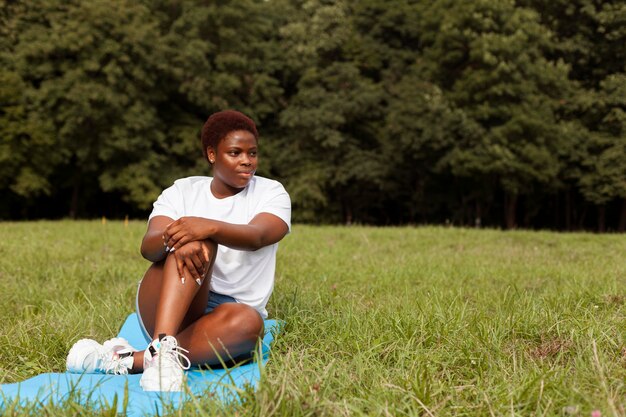 Vue de face de la femme se détendre dans la nature