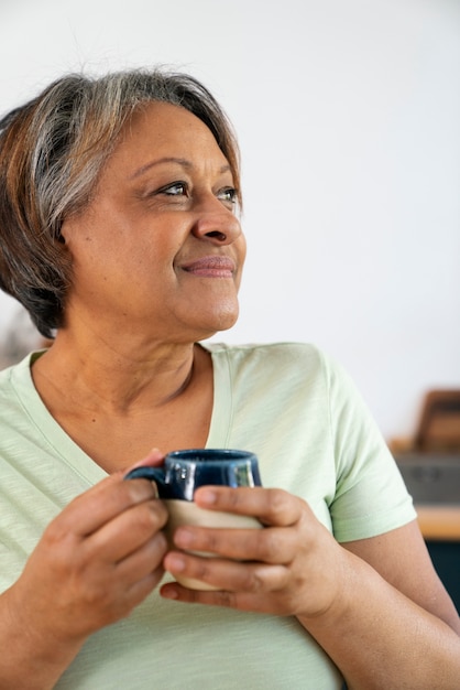 Photo gratuite vue de face femme senior avec une tasse de café