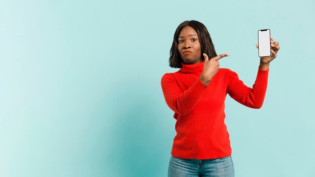 Vue de face femme avec smartphone en studio