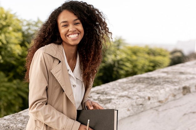 Vue de face femme smiley tenant un livre avec copie espace