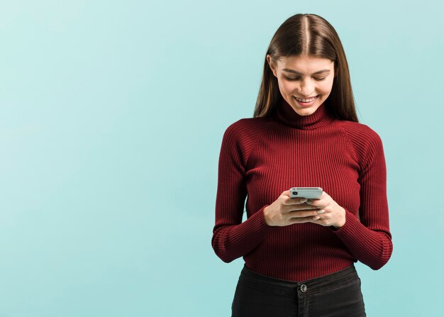 Vue de face femme sur son téléphone