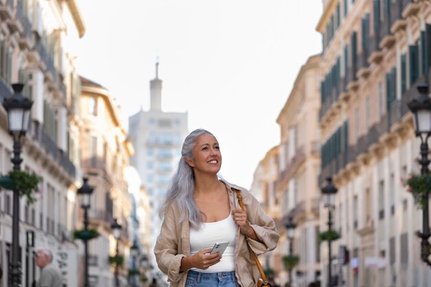 Vue de face femme souriante marchant dans la ville