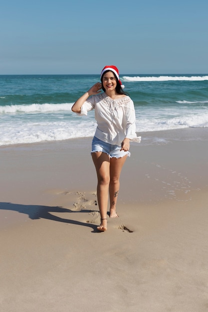 Vue de face femme souriante marchant sur la plage