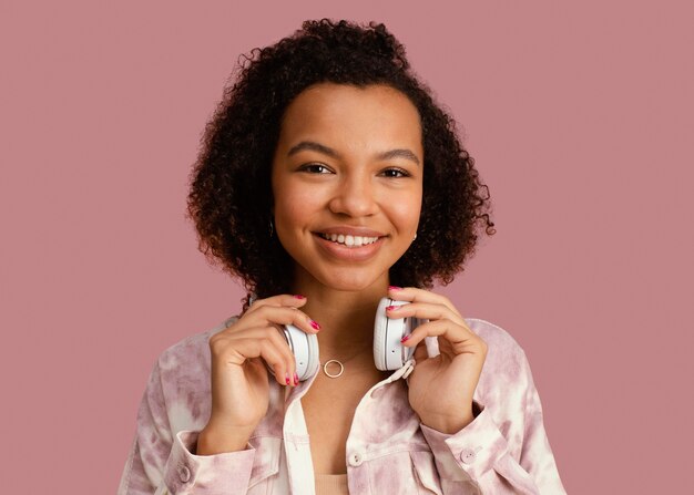 Vue de face de la femme souriante posant avec un casque