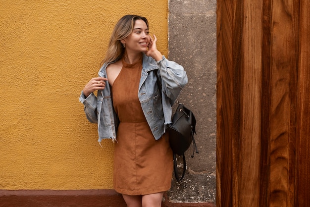 Vue de face femme souriante posant à l'extérieur