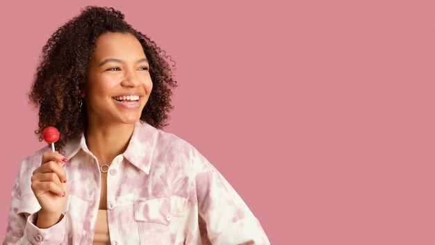 Vue de face de la femme souriante avec sucette et espace copie